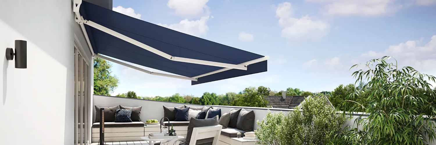 Luxury navy blue retractable folding arm awning installed on a modern white balcony, providing sun protection for an outdoor lounge area with a scenic view in Sydney.